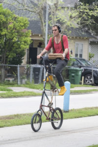 A man on a tall bicycle carrying pizza boxes finds a new way to social-distance, from high above. (Photo by F. Carter Smith)