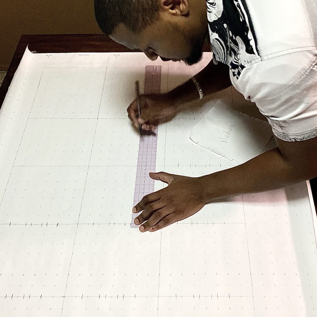 Dallas fashion designer Venny Etienne, measuring fabric for masks at his Levenity studio.