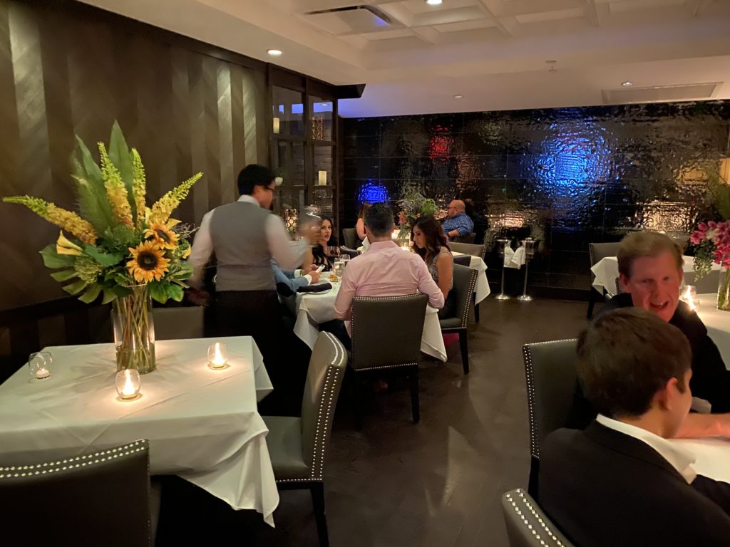 Bountiful arrangements of flowers separate tables as Steak 48 works to limit occupancy to the dictated 25 percent. (Photo by Shelby Hodge)