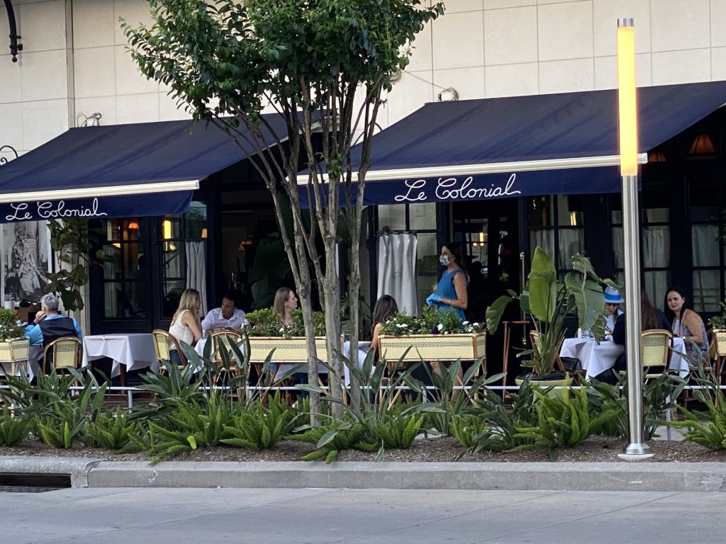 Le Colonial maitre 'd Suzanne Nagel in requisite gloves and mask while visiting with guests on the patio. (Photo by Shelby Hodge)