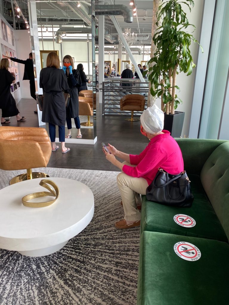 Bella Renova Salon client in a disposable towel waits on a sofa with clear social distancing marcation. (Photo by Shelby Hodge)