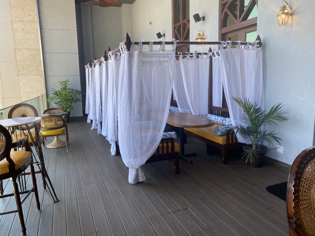 The outdoor lounge at Musaafer is complimented by daybeds draped colonial style in linen and featuring plump bolsters. (Photo by Michael Anthony)