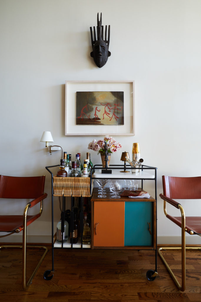 The bar cart, designed by Arthur Umanoff in the '70s, was purchased in South Beach. Mart Stam 1980s brass and leather chairs. African mask from David Lackey Antiques & Art. Al Souza painting. (Photo by Pär Bengtsson)