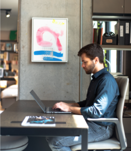 CAM Studio’s Roger Leal Martinier at his desk with a work by L.A. painter Martin Durazo, “LOV-R,” 2015, represented and curated by Barbara Davis Gallery. (Photo by Krzysztof Kwiatkowski) 
