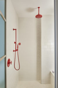 Red plumbing fixtures in the bath rooms carry out the Virgin Hotels color theme.