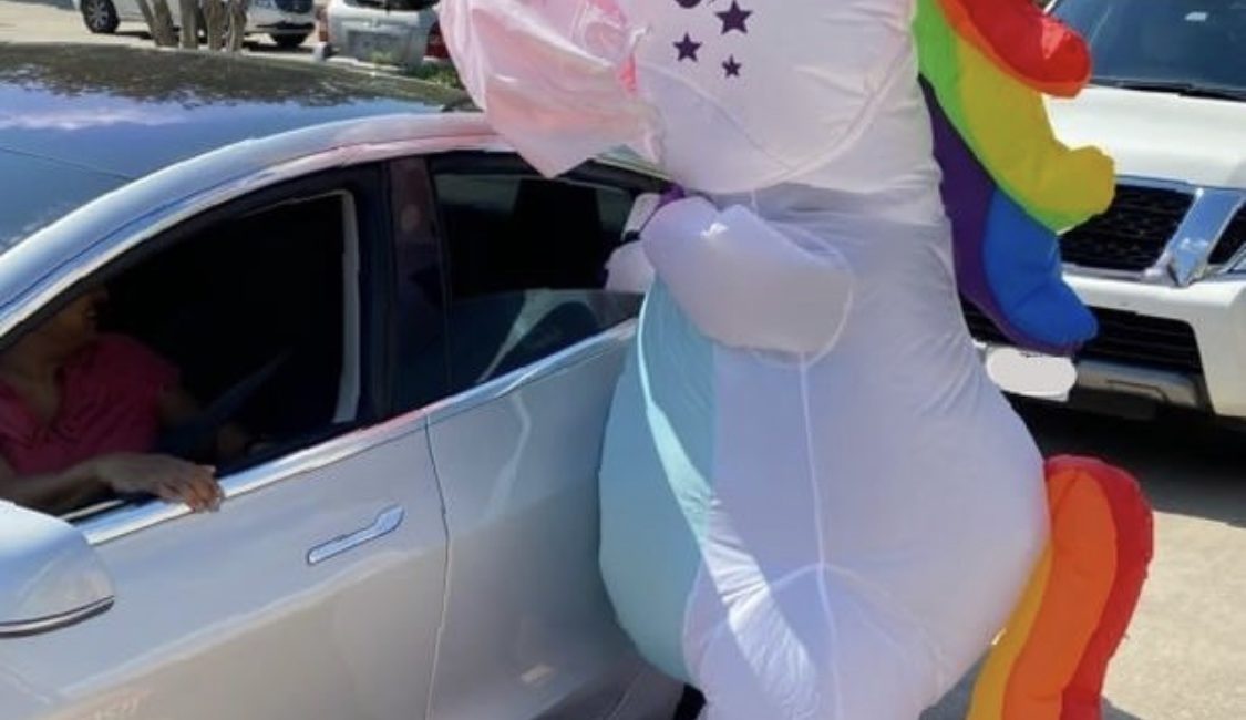 Sparkles the Unicorn delivering children’s books to a family at the Houston Public Library Stella Link location.