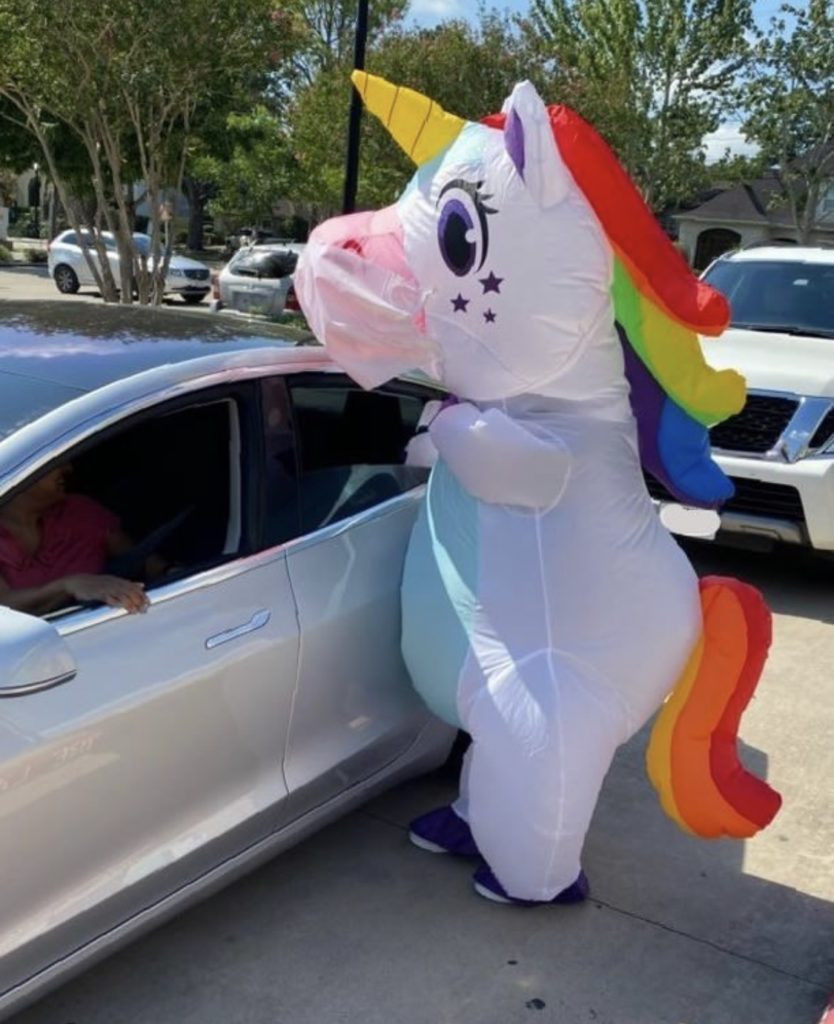 Sparkles the Unicorn delivering children’s books to a family at the Houston Public Library Stella Link location.