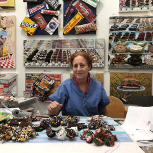 Artist Diane Gelman in her Houston studio working on a 3D-piece evoking toothsome chocolates. Gelman was recently commissioned by gallerist/collector/patron Bryn Larsen to transform a room in her new home into a sweet-lovers dream. (Photo courtesy the artist) 