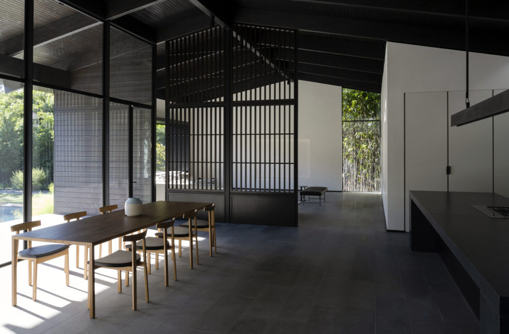 A vertical screen separates the open dining/kitchen expanse from the great room.  (Photo by Jack Thompson Photography)