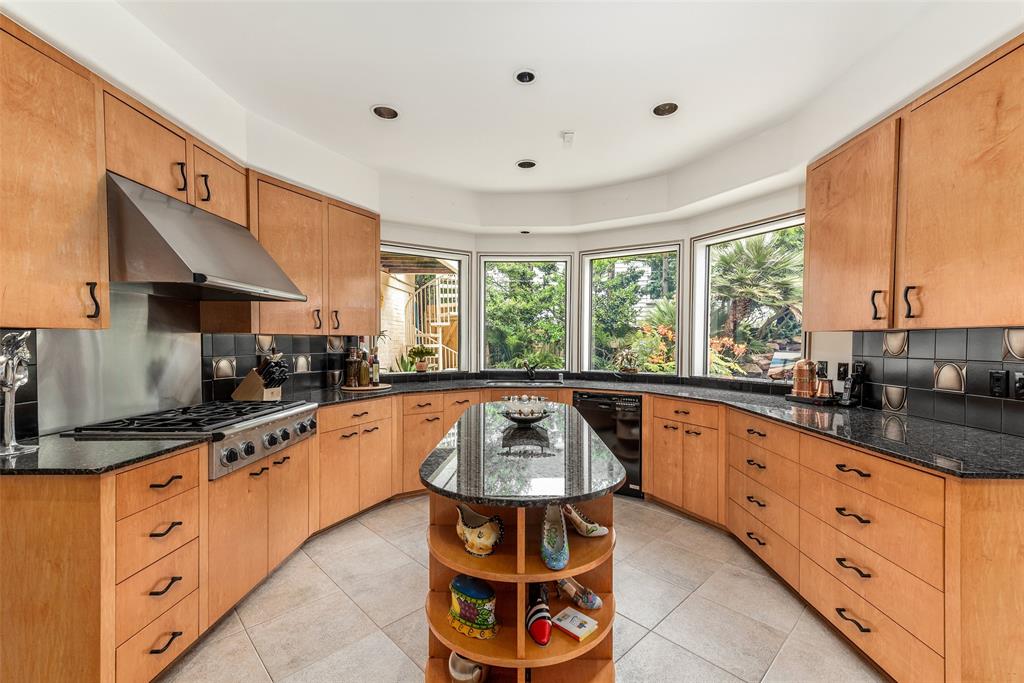 The modern kitchen boasts two islands and has views into the verdant atrium.