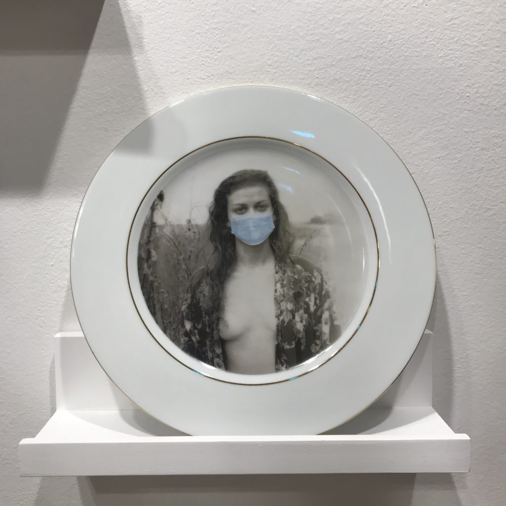 "Wear Your Mask" gold-rimmed porcelain dinner plate from "Masks Women Wear," a wall installation comprised of a baker's dozen of plates, each graced by a different image. (Photo by Mary Margaret Hansen)