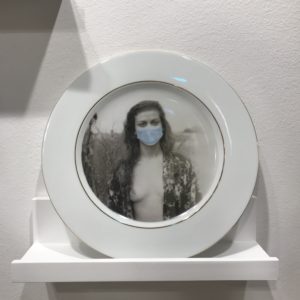 “Wear Your Mask” gold-rimmed porcelain dinner plate from “Masks Women Wear,” a wall installation comprised of a baker’s dozen of plates, each graced by a different image. (Photo by Mary Margaret Hansen)