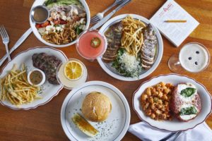 Steak Frites, Beverly Salad, French Chicken, Espresso Martini, Chicken Parm, The Cheeseburger, Stone Fruit Martini, and The Cabo Martini (Photo by Courtesy of Vandelay Hospitality Group)