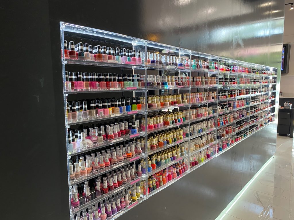 The wall of nail polish delivers  exciting  visual impact to the salon.