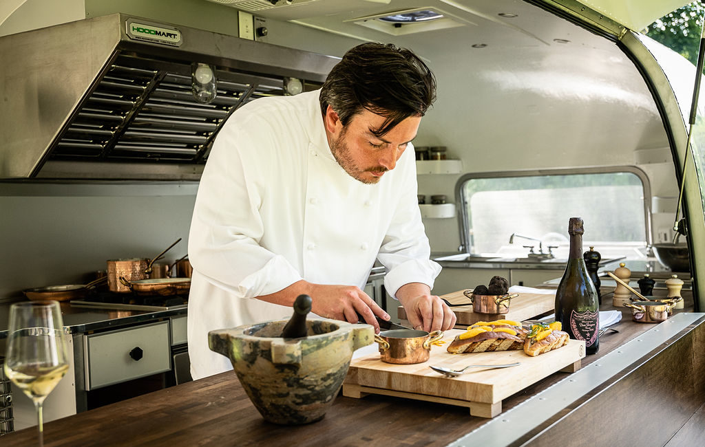 Chef Yann Nury works in the Airstream trailer kitchen that is open to diners while he prepares their meals.