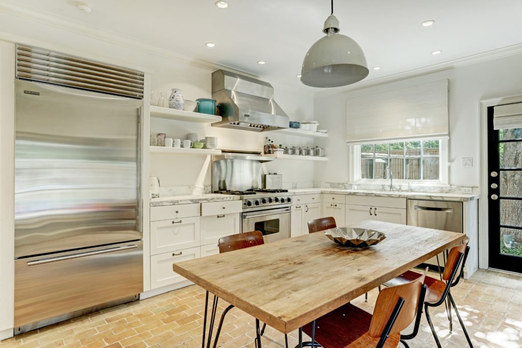 The updated kitchen features antique brick flooring and contemporary utilities. (Photo by TK Images)