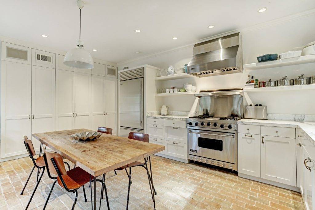 The updated kitchen features antique brick flooring and contemporary utilities. (Photo by TK Images)