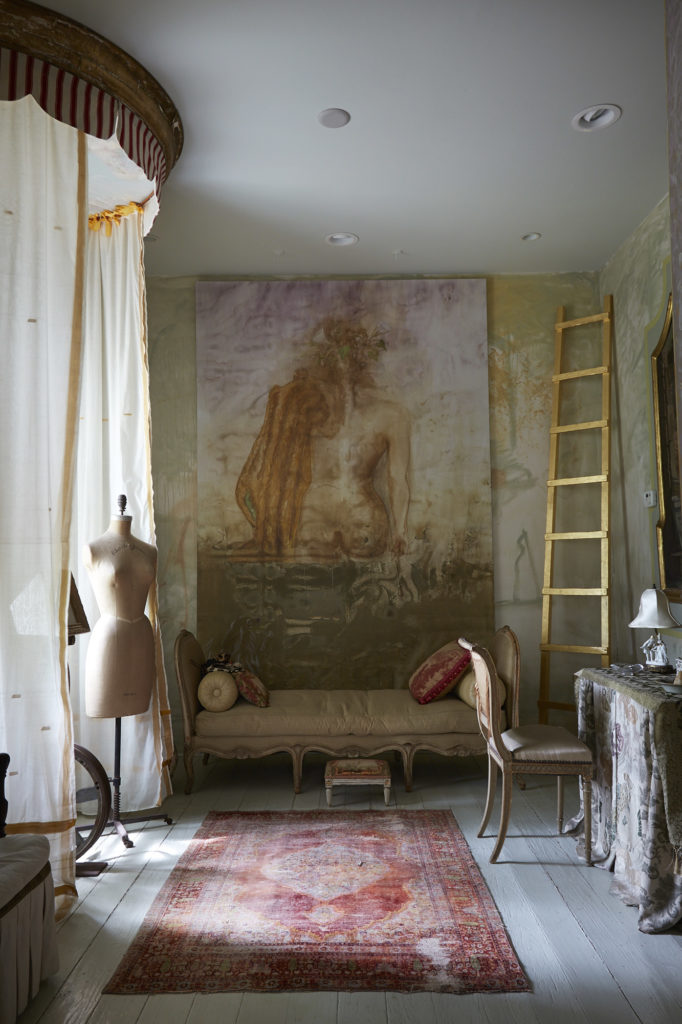 A dreamy room in a cottage called Here & There. Gilded ladder and painting are by Salle Werner-Vaughn. Antique sari fabric at the window. Vintage dressmaker's form once belonged to Charles James. (Photo by Lisa Petrole, Art Direction by Michelle Aviña)