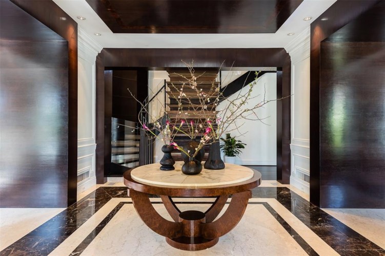 A marble-lined entry showcases soaring dual staircases. (Photo by Alex Perry, Allie Beth Allman & Assoc.)