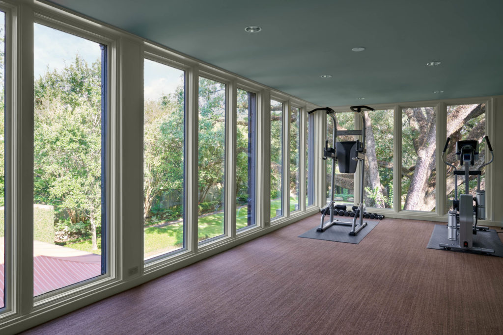 The original wrought iron sleeping porch located on the north side of the home has been enclosed and currently serves as the gym at 2 Longfellow Lane in Houston's swank Shadyside enclave.  (Photo by Nathan Schroder/Douglas Elliman)