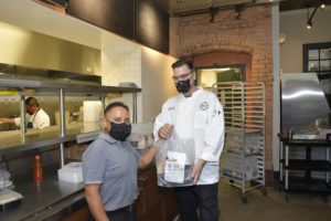 Potente Chef Danny Trace hands off a dinner package from the kitchen at Minute Maid Park. (Photo by Jerry Klump)