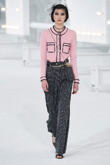 Houston model Sherry Shi  walks the runway at the Chanel fashion show in a classic Chanel pink sweater blouse and black slacks. (Photo courtesy of Chanel)