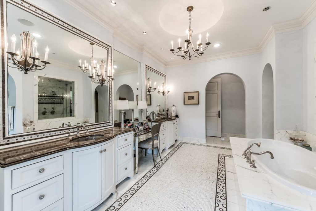 The master bath is Hollywood glamour with huge soaking tub and inlaid mosaic tile floors.