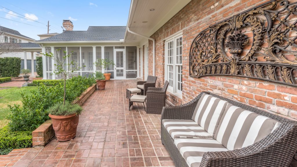 The backyard patio and screened porch with a view to the park-like greenspace.