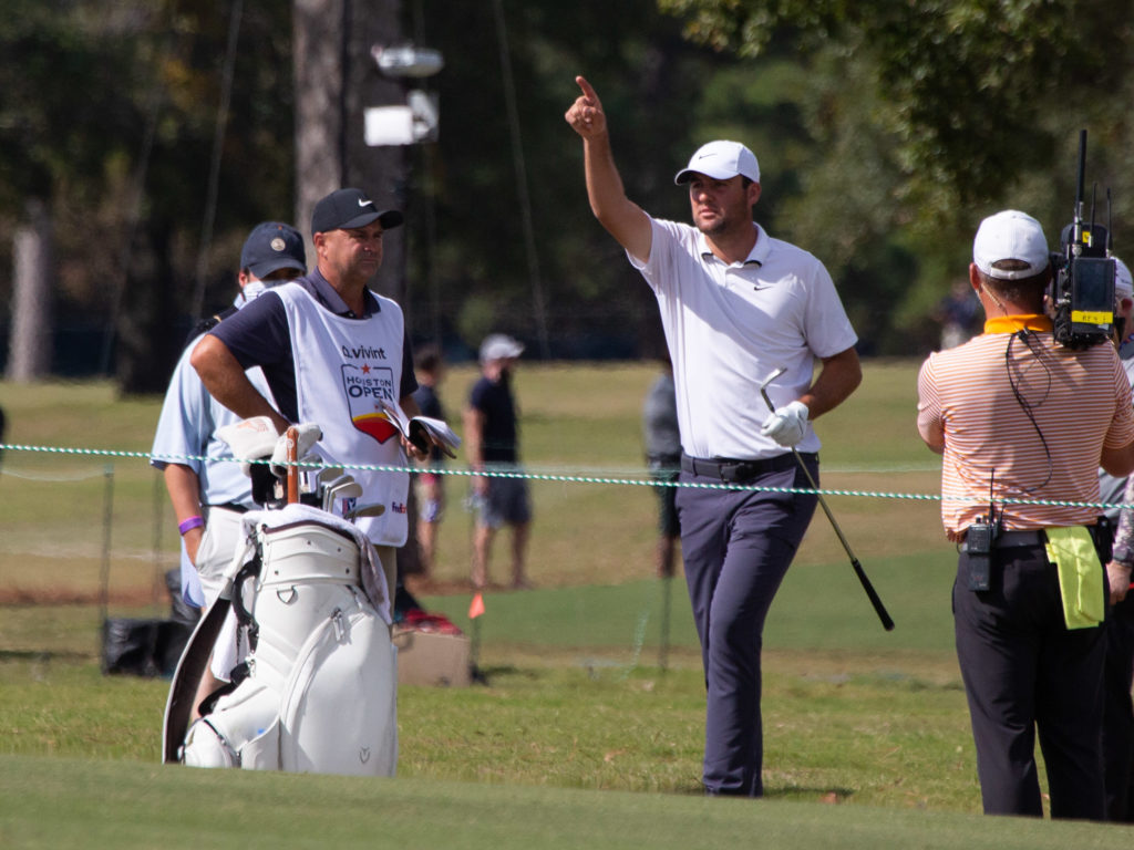 Scottie Scheffler of Dallas signals fellow golfer Tom Hope to hit his approach shot on hole number 18. (Photo by F. Carter Smith)
