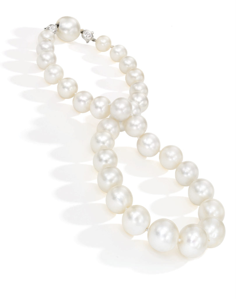 <b>A Rare Natural Pearl and Diamond Necklace</b>
Composed of 32 natural pearls measuring approximately 14.9 x 14.8 to 9.2 x 9.0 mm, the clasp accented with two round diamonds in floral mountings, length 16¾ inches.
Estimate $300/500,000
