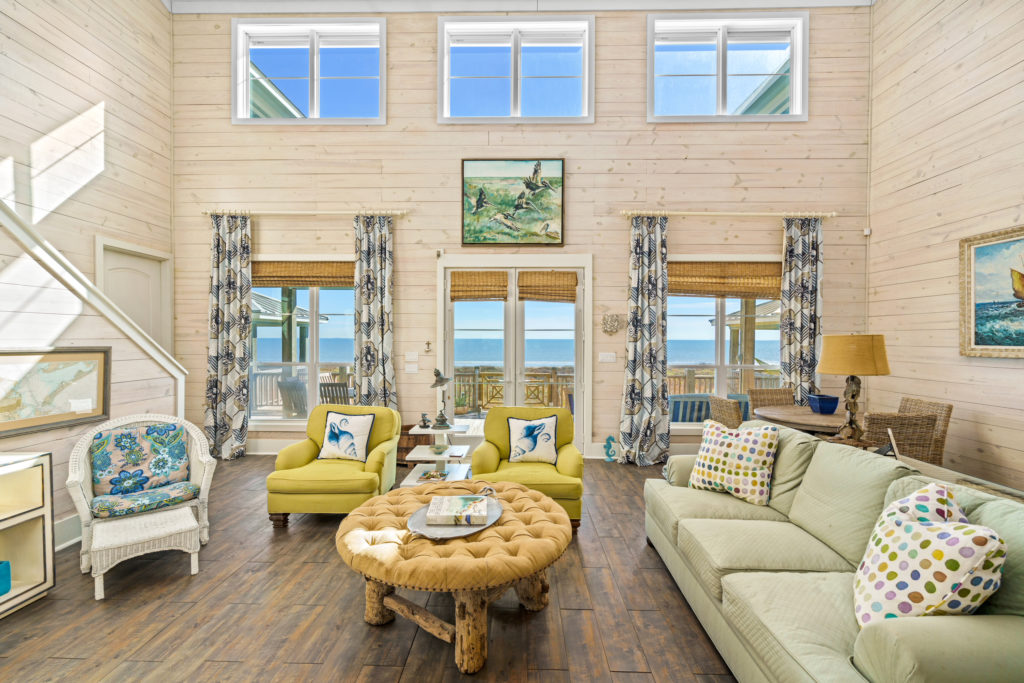 Design features include vaulted ceiling in the living and dining areas where whitewashed shiplap walls give a nod to the beachfront location.