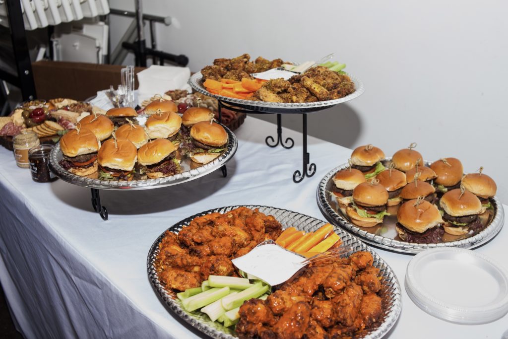 While they mingled across the tables, guests munched on American bites including hamburger sliders, hot wings, and an assortment of cheeses. (Photo by Julian Cavazos)