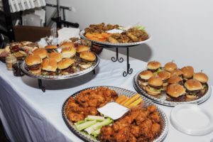 While they mingled across the tables, guests munched on American bites including hamburger sliders, hot wings, and an assortment of cheeses. (Photo by Julian Cavazos)