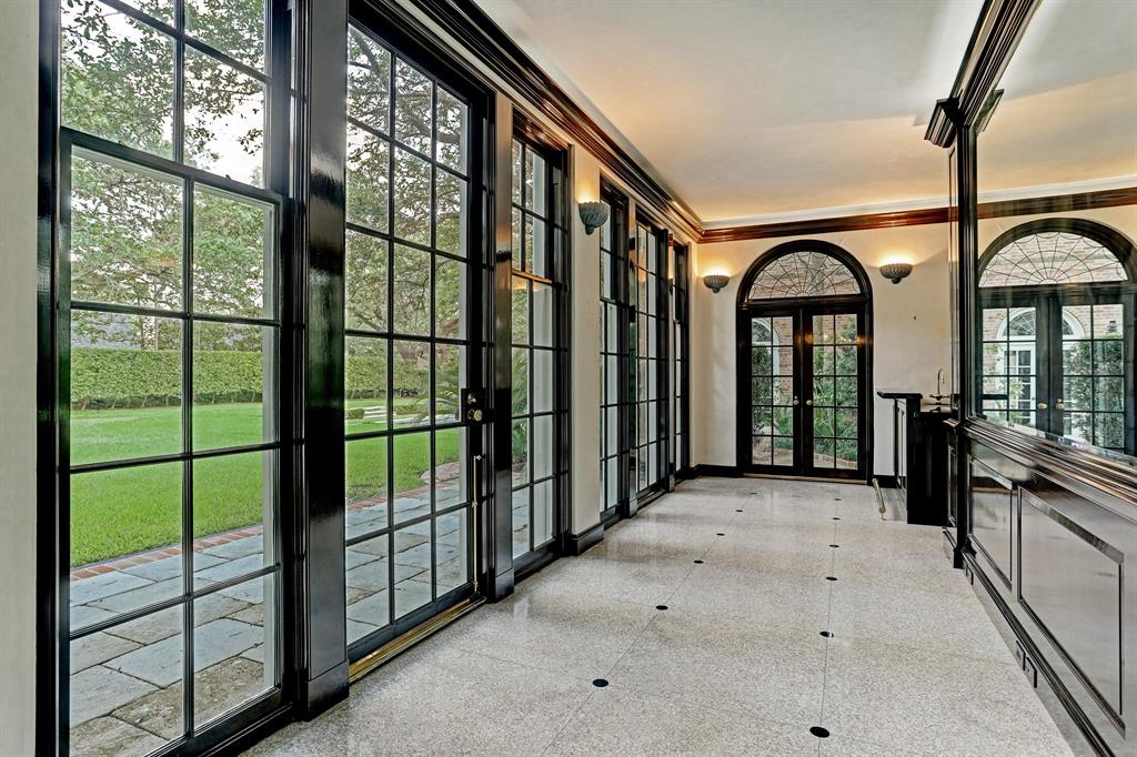 Fanciful Chinese-Chippendale wooden gates at 3229 Groveland announce the sun-lit rear gallery floored in terrazzo inlaid with black granite rondels. 
