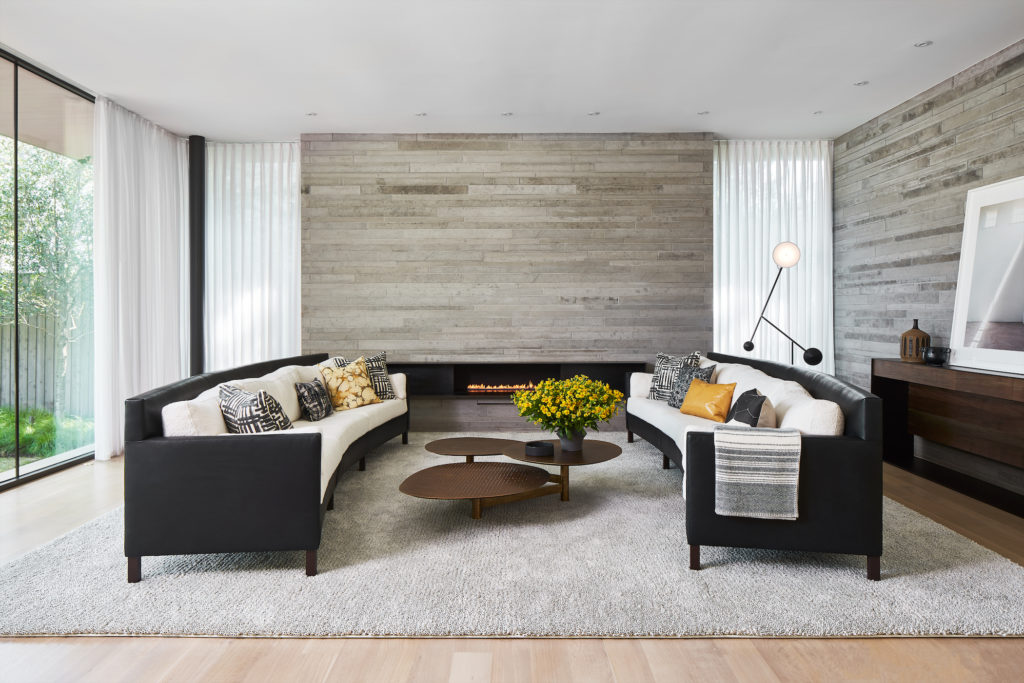 The living room’s custom sofas are in leather and wool bouclé. Ligne Roset lamp. Coffee table from Cantoni Trade. Mark Jupiter credenza. Thom Jackson’s "Judd Gym" photograph. (Photo by Stephen Karlisch )