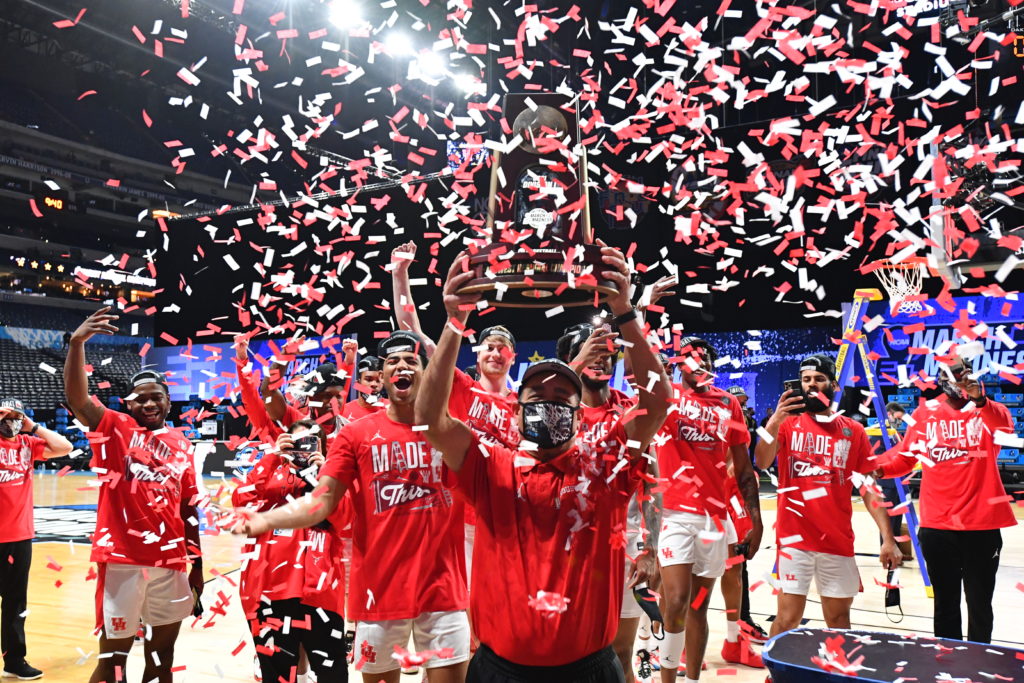 Kelvin Sampson holds the regional champions trophy up as his players holler and the confetti falls. (Photo by Brett Wilhelm/NCAA Photos via Getty Images)