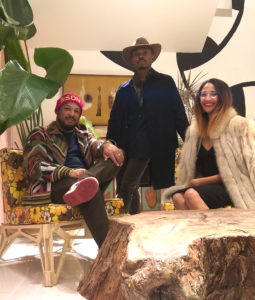 From left: Curator/artist Robert Hodge, artist Preston Gaines, and producer India Lovejoy hang out on bold chairs near a tropical environment made by Gaines. (Photo by Catherine D. Anspon)