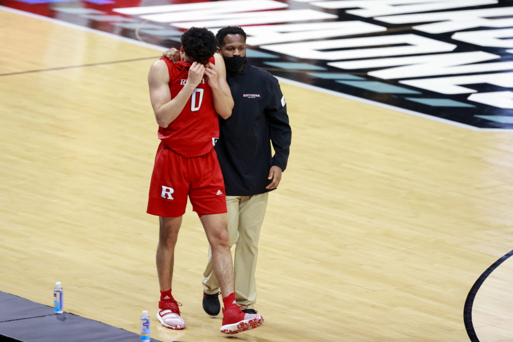 The other side of March Madness is the sadness. A distraught Geo Baker of Rutgers needs to be guided off the court. (Photo by Justin Tafoya/NCAA Photos via Getty Images)