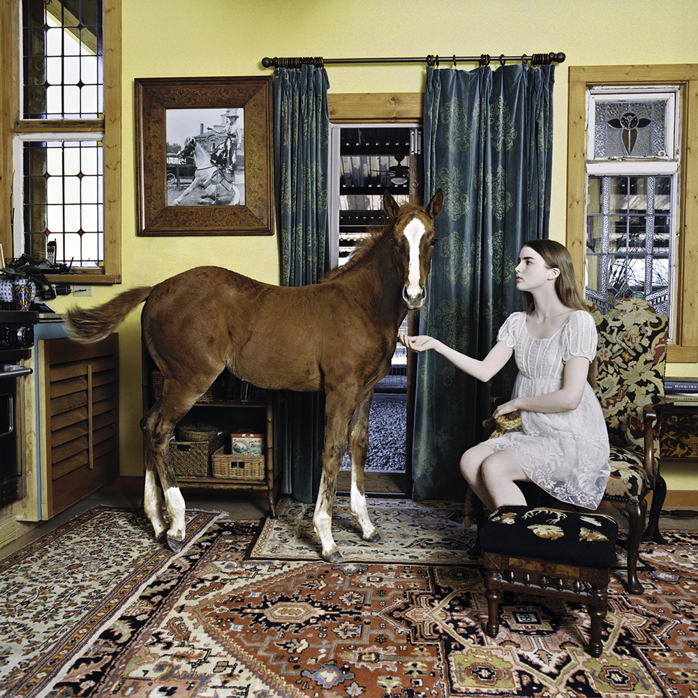 Laura Wilson's "Young Girl with Colt in Living Room, Weatherford, Texas," 2006, at Red & White Gallery. 