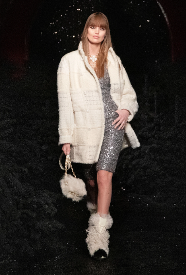 Chanel sequined dress, white knit coat, faux fur purse and Moon Boots. (Photo courtesy of Chanel)