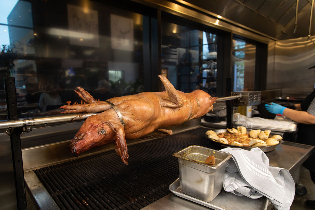 Roasted pig is one of the specials that pop up on the rotisserie at Levy Park's Woodshed Grill. (Photo by Leah Wilson)