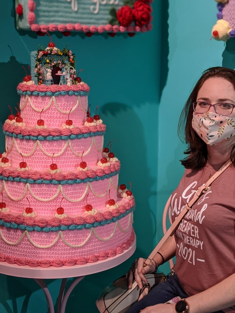 
Elizabeth Moeller in a cafe bakery inspired themed room next to her idol Twinkie Chan's crocheted tiered cake that looks good enough to eat. (Photo by Crystal Correa)