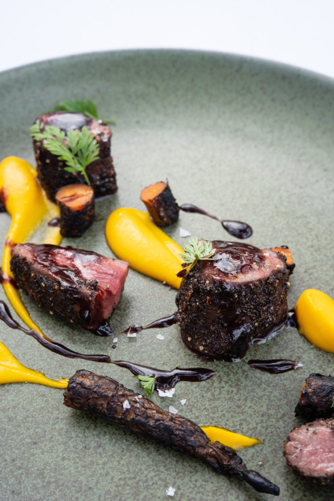 The third course : beef shoulder, red mole, and marigolds. (courtesy of Collective Retreats)