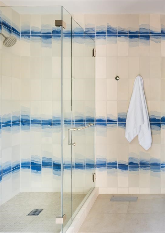 Watercolor tiles add a memorable touch to a walk-in shower. 