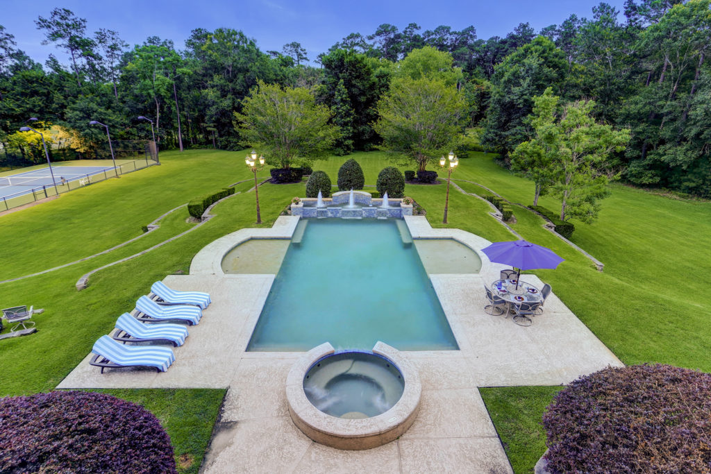The pool with fountains/waterfall at one end is a focal point of the backyard. (Photo by TK Images)
