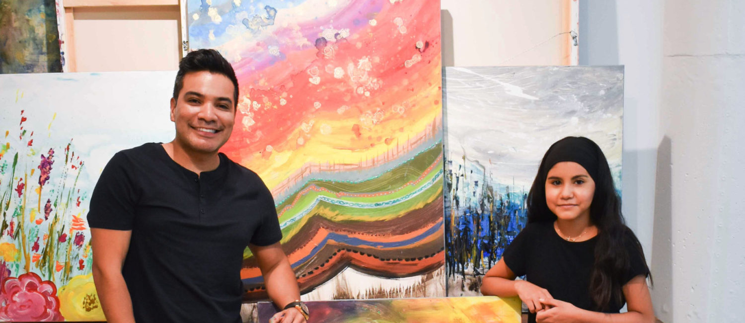 Edgar Medina and Melinda Moreno pose beside their collaboration, “Summer,” 2021.
