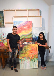 Edgar Medina and Melinda Moreno pose beside their collaboration, “Summer,” 2021.