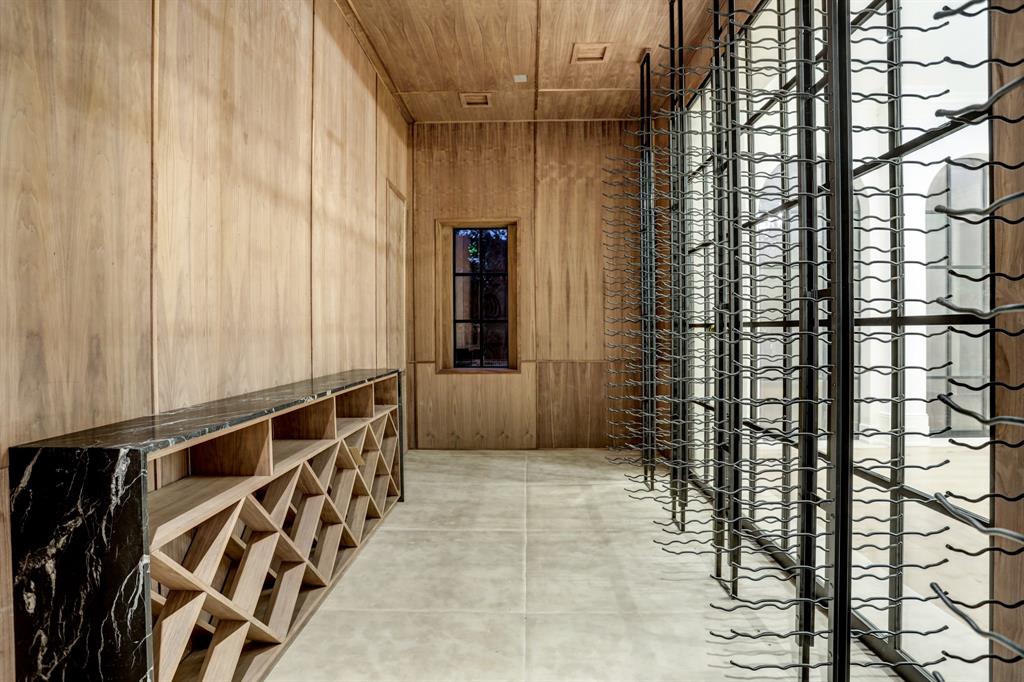 The wine room at 3001 Inwood accommodates 2,000 bottles and overlooks the dining room via a steel framed window. (Photo by TK Images)