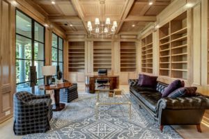 The study at 3001 Inwood with floor to ceiling white oak block paneling, box beamed ceiling, built in bookcases and cabinet storage, three sets of 10′ steel and glass double doors to a covered terrace. (Photo by TK Images)