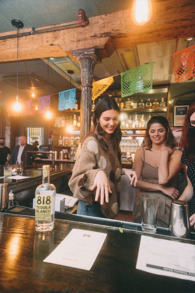 Kendall Jenner and Blayne Fertitta shake it up with Jenner's 818 Tequila at Tilman Fertitta's Dos Caminos in New York's Meatpacking District. (Photo by Sophie Sahara)
